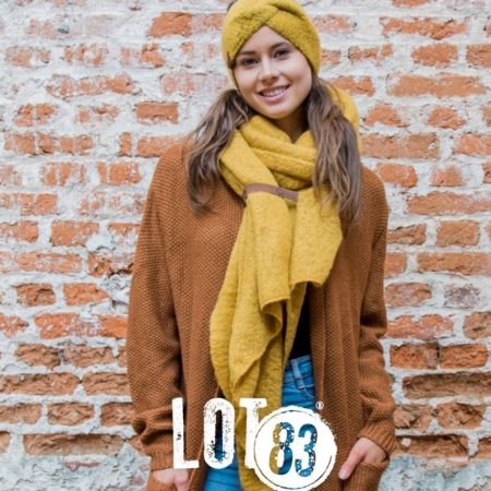 Der ockerfarbene Damenschal FEM von Lot83 mit Stirnband trägt nicht auf. Dieser Schal ist angenehm weich - aus kuscheligem und warmen Fleece.
